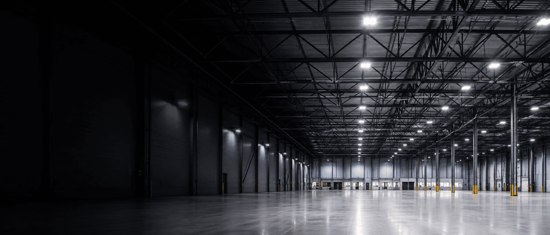 Dark high-bay warehouse interior lit by round LED high-bay fixtures