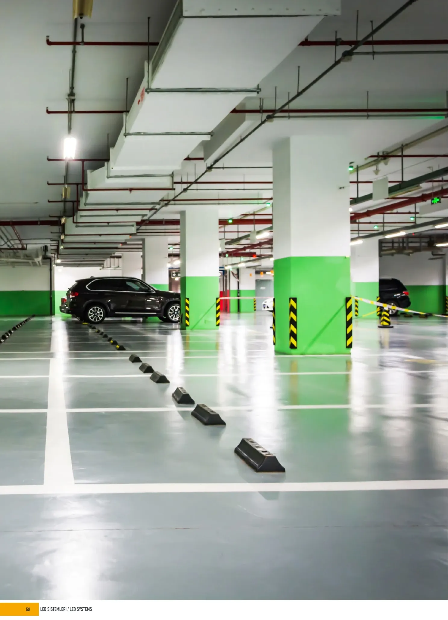 Covered car park interior beneath linear ceiling lighting