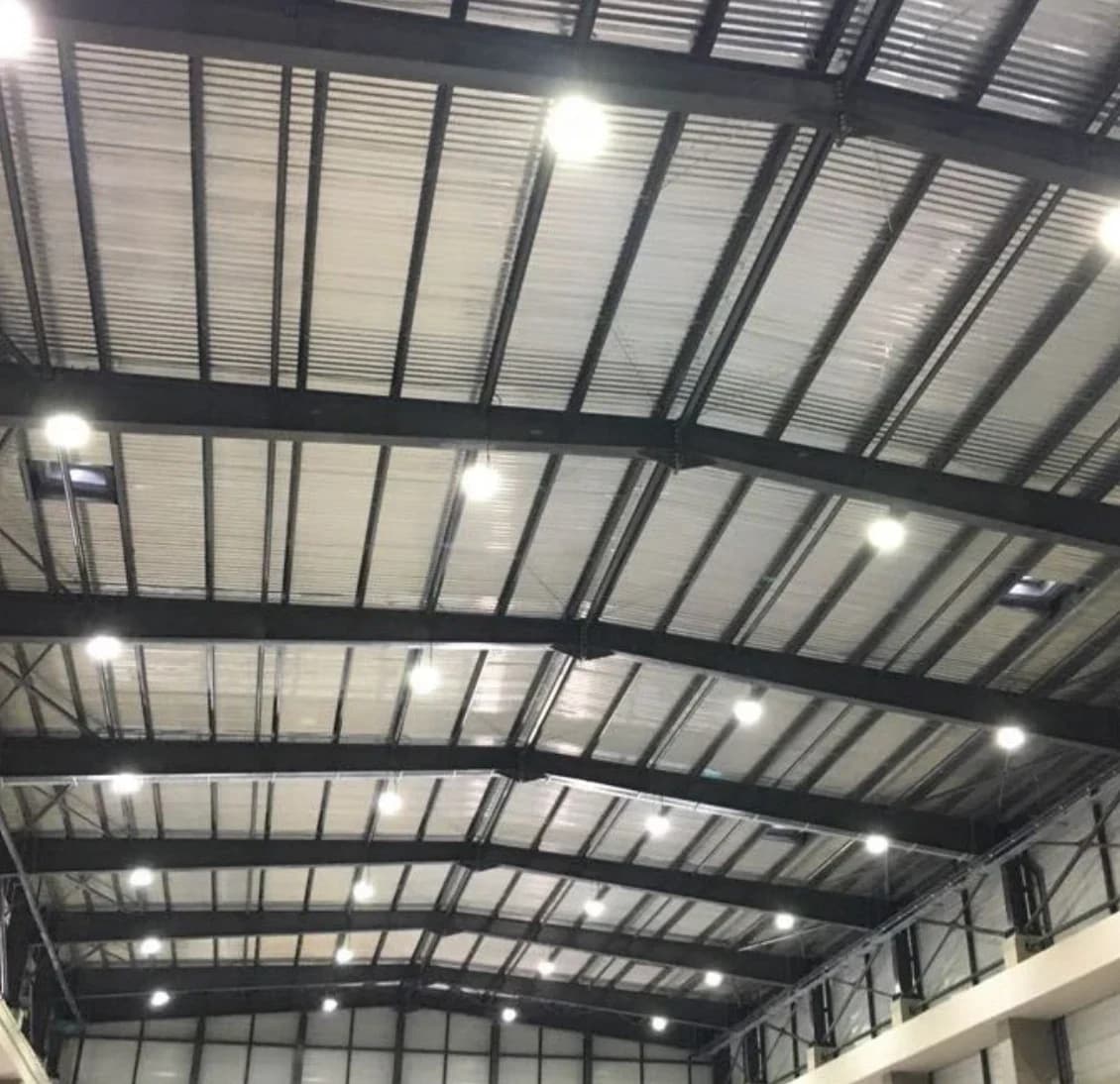 Industrial warehouse roof structure lit by high-bay LED fixtures