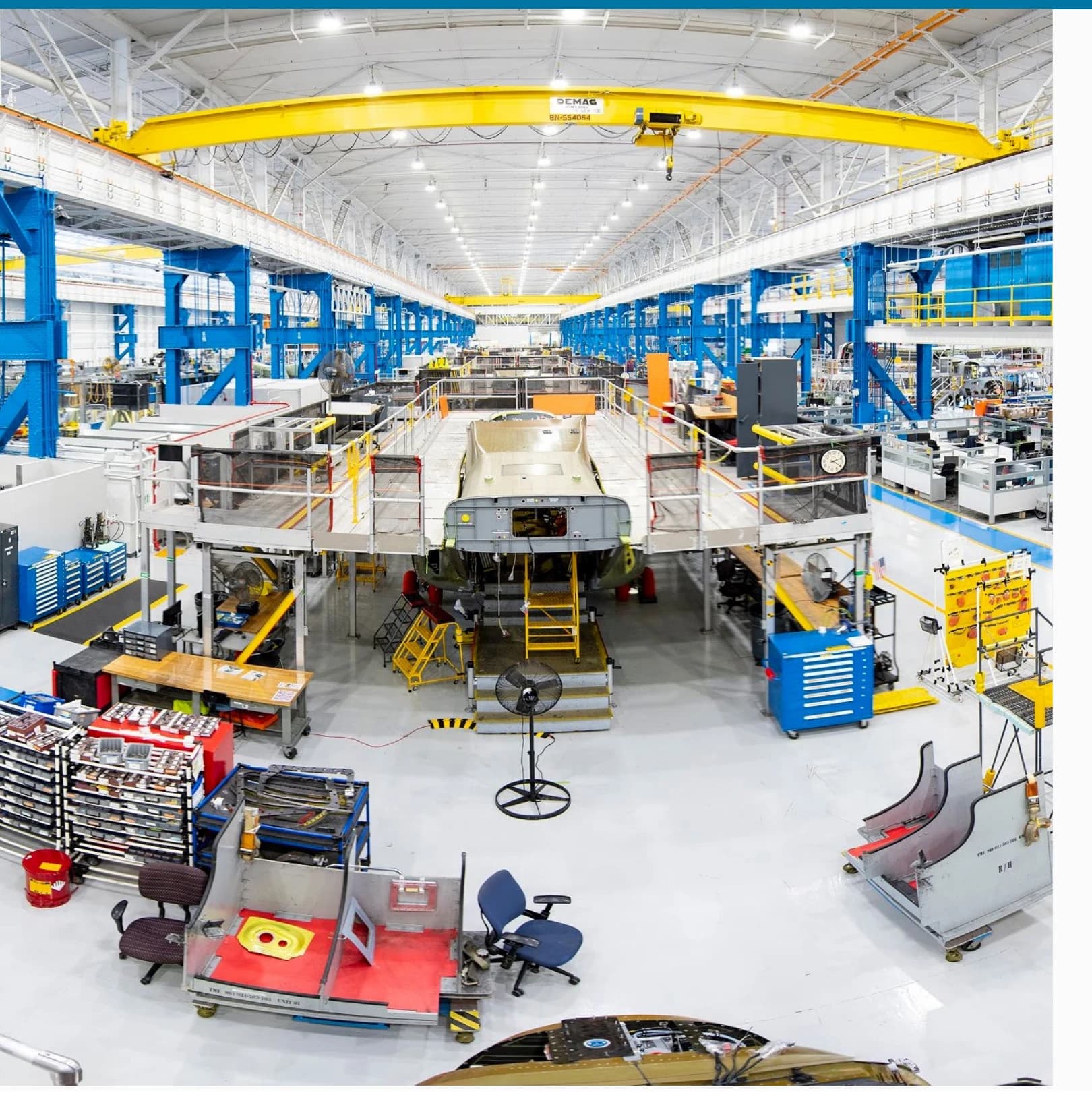 Large-span industrial facility interior with overhead crane, lit by high-bay LED fixtures